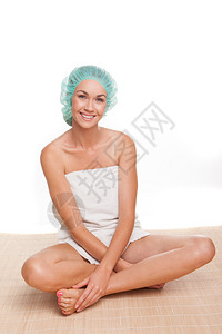 穿着浴帽的漂亮女人坐在地板上交叉腿吊在地上带着美图片
