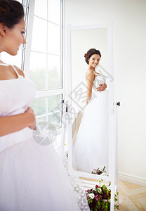 年轻美丽的新娘在商店试穿图片