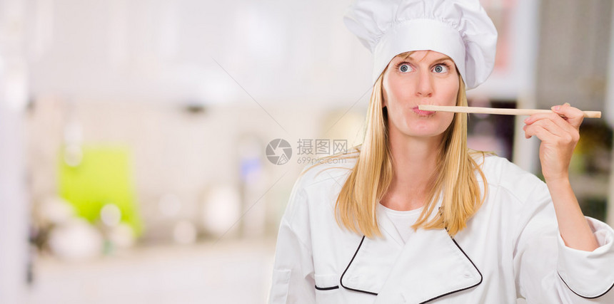 女厨师在厨房品尝食物图片