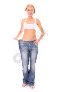 照片中一位年青的健壮女人穿着太大的牛仔裤成为白背背景图片