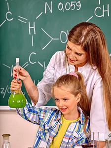 女孩和化学老师在化学课上拿着化学图片
