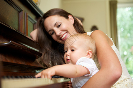母亲在婴儿弹钢琴图片