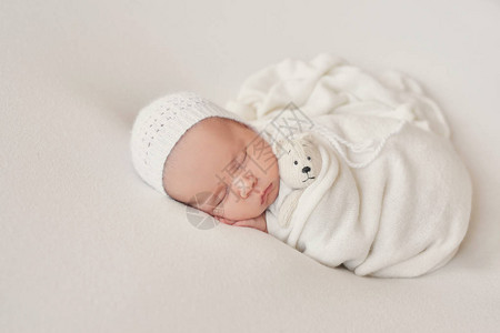 可爱的新生婴儿躺在白色的毯子里婴儿用品包装模板新生婴儿的特写肖像图片