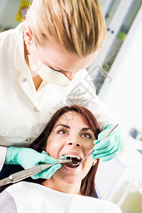 女牙医用牙钻修复办公室女病人的牙齿选择聚图片