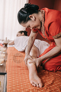 Asian按摩师在温泉沙龙为女做足部按摩图片