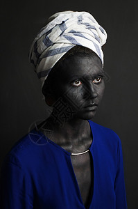 一名身戴白色缠头巾的女孩和涂着黑色灰黑漆的蓝色上衣皮图片