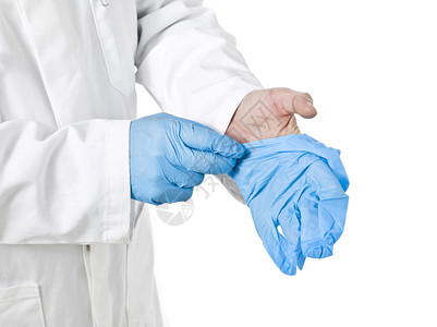 一名男医生身戴蓝色医疗手套时被白色背景隔绝的白图片