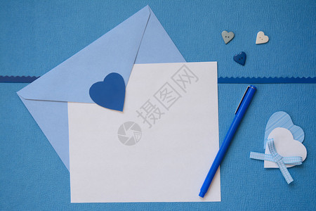 蓝色信封和白色纸与手工制作的心工艺品图片