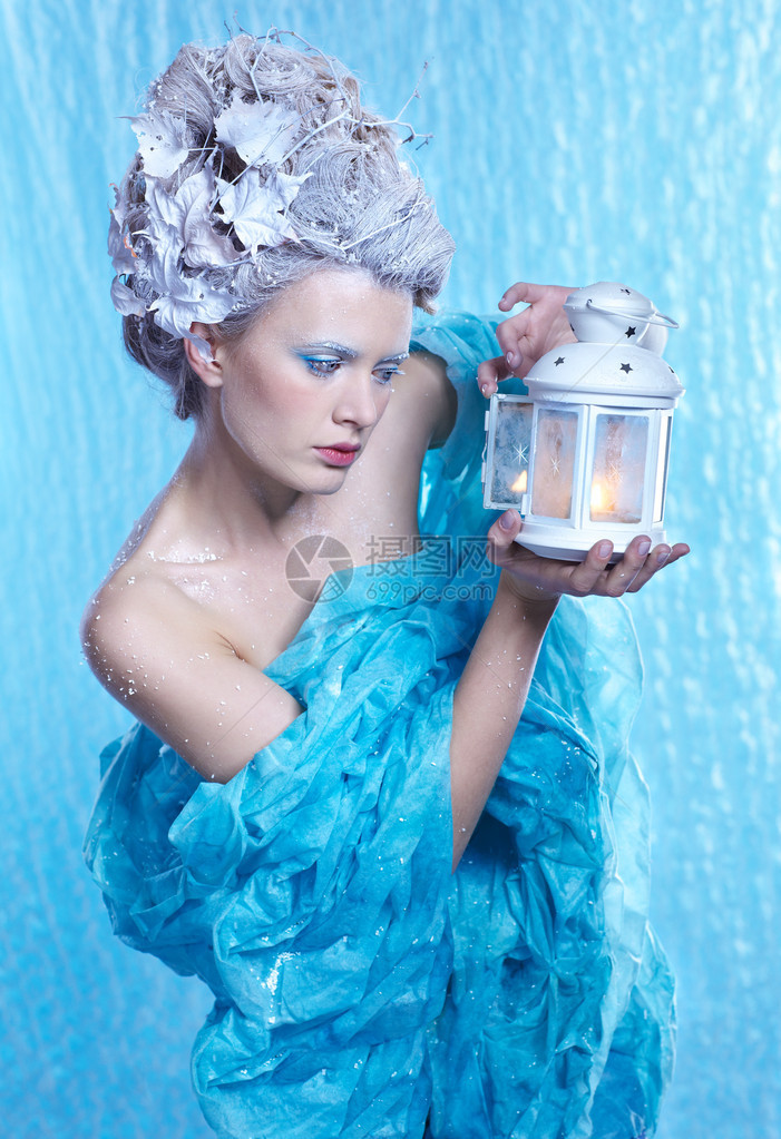 美丽的年轻女子用在冰冻的蓝色上成像冰仙图片