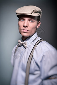 穿蓝衬衫领带和弓领带帽子的时尚男郎图片