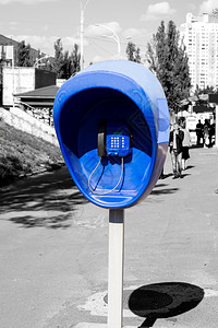 在城市黑白街道上安装蓝色公用电话的支柱图片