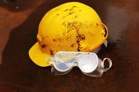 生锈背景下的安全设备头盔和护目镜图片