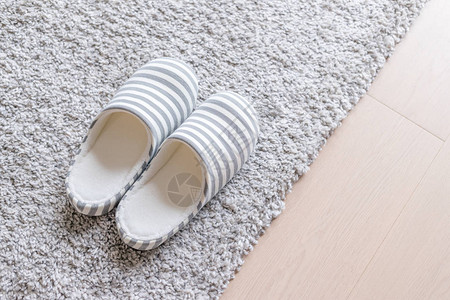家里地板上的地毯上的拖鞋背景图片