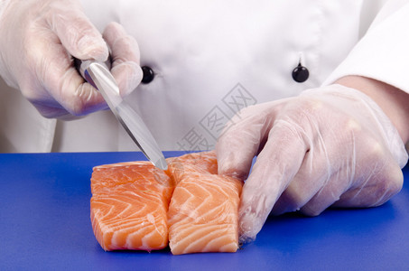 女厨师用菜刀切鲑鱼片图片