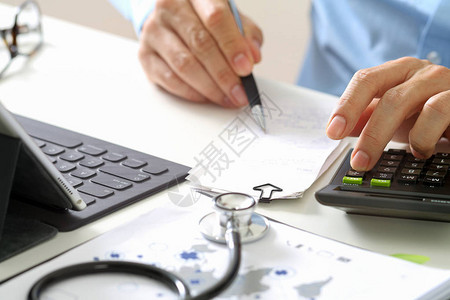 医疗费用和费用概念智能医生的手在现代医院使用计算器图片