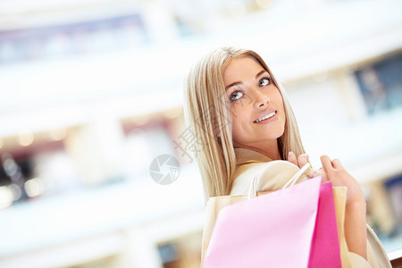 商店里提着包的年轻女孩背景图片