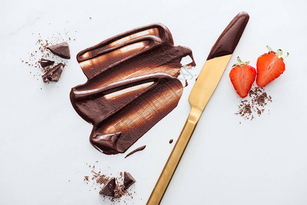 盛有草莓液体巧克力巧克力棒片和可粉的金桌图片