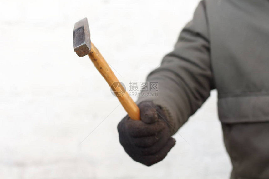 铁锤手握着木柄用黑色手套在白色背图片