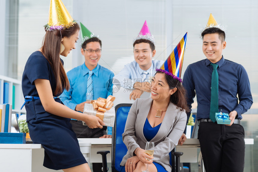 年轻经理在办公室派对上给同事送生日礼物图片