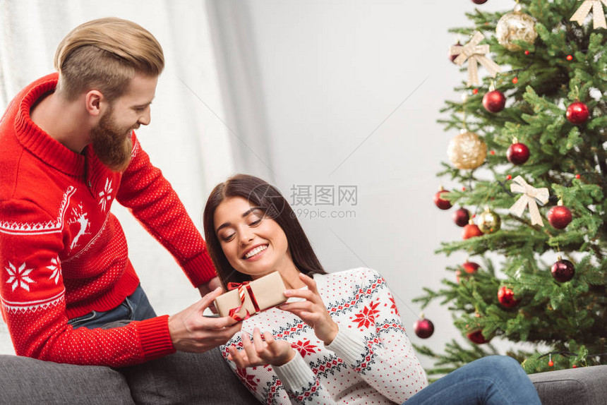 英俊的长胡子男人把圣诞节礼物给图片