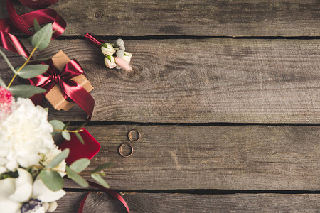与结婚戒指首饰盒新娘花束和木桌顶上的图片