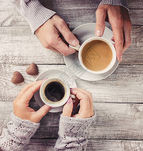 一个男人和一个女人拿着杯子手里拿着咖啡图片
