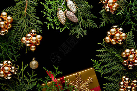 闪亮的金色圣诞装饰绿色图华树枝和礼品盒之顶背景图片