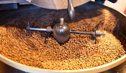 在咖啡烘焙机中烘焙的绿色咖啡豆图片