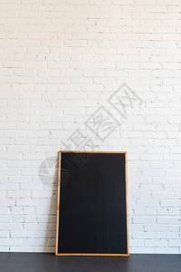 木框里的空黑板站在白砖墙上图片