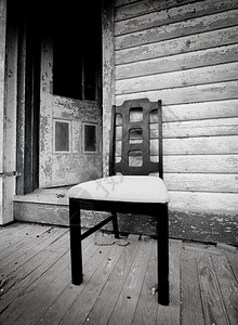 一辆黑色椅子坐在弃屋门图片