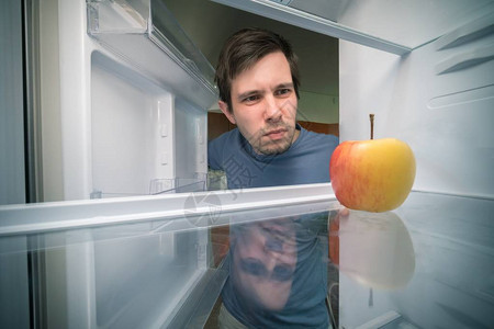 饿了的人在冰箱里找吃的只有苹果在图片