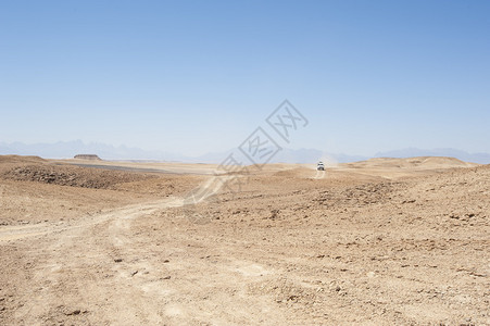 在荒漠的荒漠地貌上乘坐越野车图片