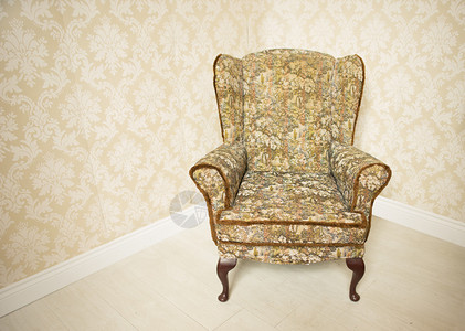 时尚的空软垫金色复古扶手椅站在房间的角落里图片