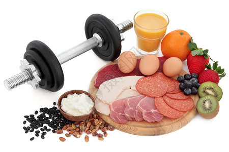 肉坚果豆类干酪水果和冰沙汁的健康和健身高蛋白食物与哑铃重图片