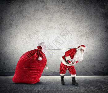 圣诞老人拖着一大袋礼物图片