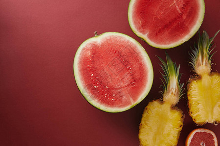 红色表面切西瓜和菠萝的顶视图背景图片