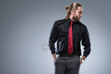 身穿黑色衬衫带红色领带的年轻胡子男向外望去图片