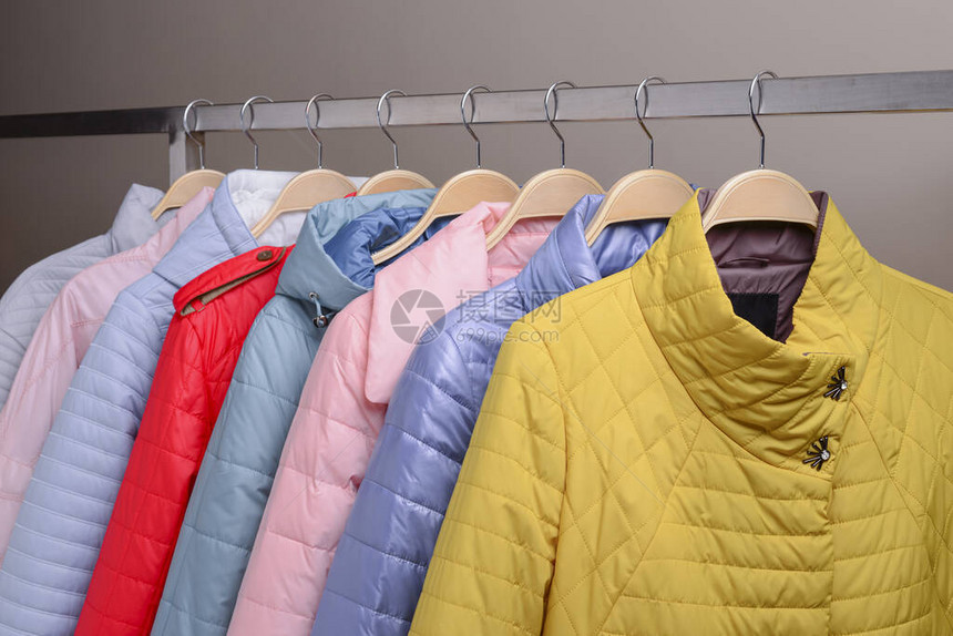市场上衣架上的新羽绒服系列现代春季秋季外衣的彩色特写商店出售图片