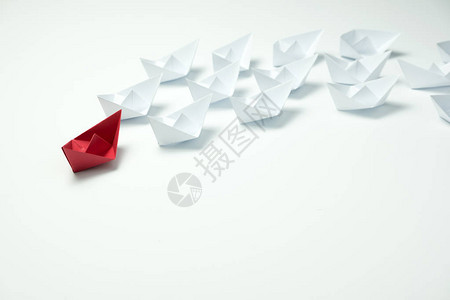 领导力概念由红纸船在蓝背景白舰中领先背景图片