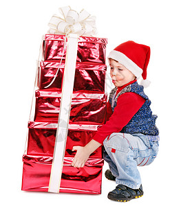 带着堆叠礼物盒的圣诞老人帽子的孩图片