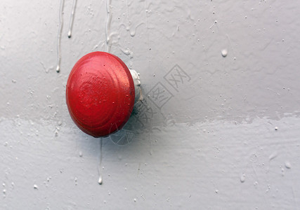 灰金属墙上的红色按钮图片