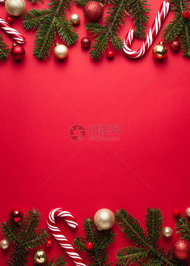红背景的圣诞和边框架Fir树枝圣诞球和糖果图片