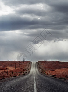 在一片阴云灰色的天空下一条直通沙漠的空路图片