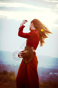 风中的年轻女子站在城上山图片