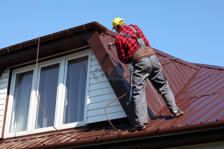 屋顶建筑工人在金属板顶上图片