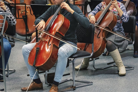 管弦乐队中演奏大提琴的人背景图片