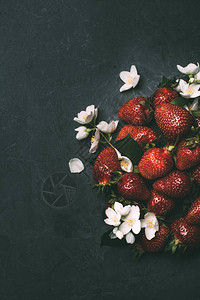 成熟的红色草莓和黑色茉莉花的顶视图图片
