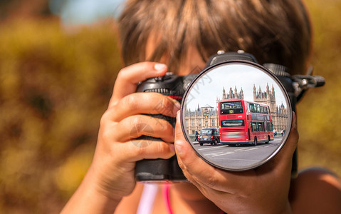 年轻女孩用专业数码相机拍摄伦敦公交车的照图片
