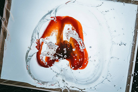 新鲜的甜椒片漂浮在水中溅起的水花图片