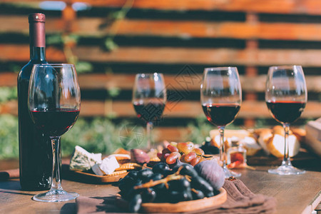 红葡萄酒杯和户外木制餐桌图片